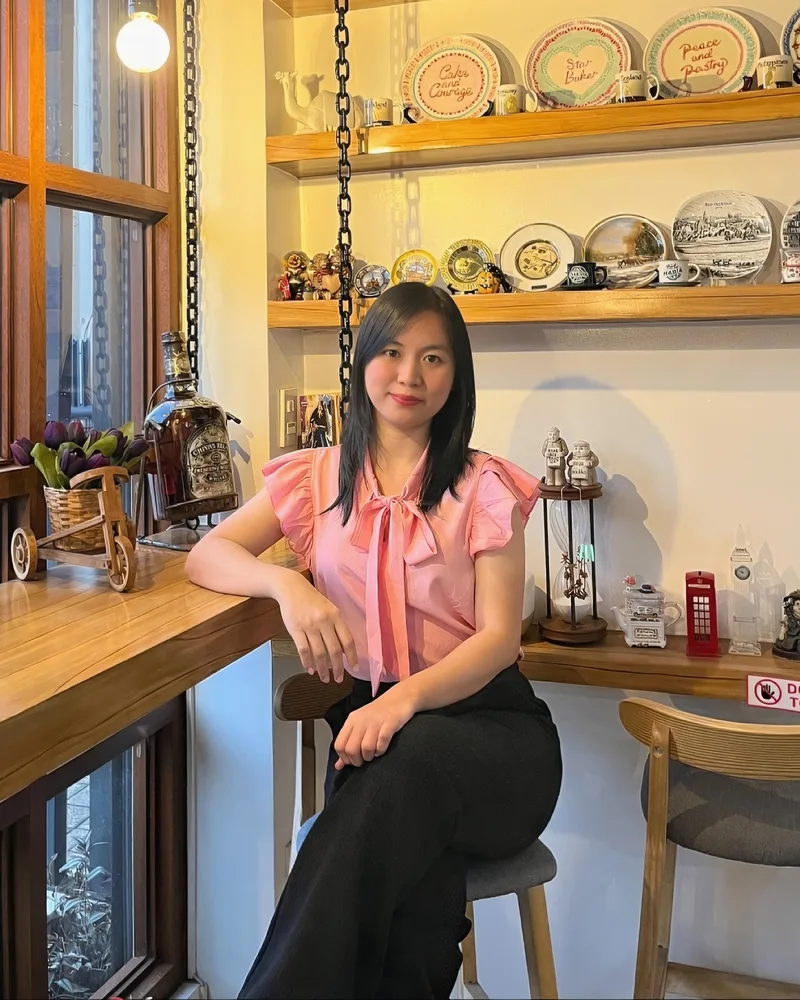 Nelvie Jean Israel, SEO and AI search specialist, seated at a café window counter
